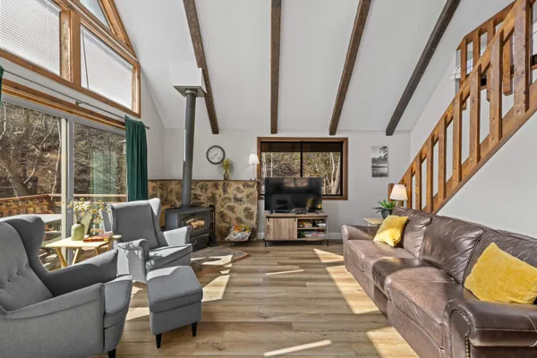 a dining room with wooden floor and large windows