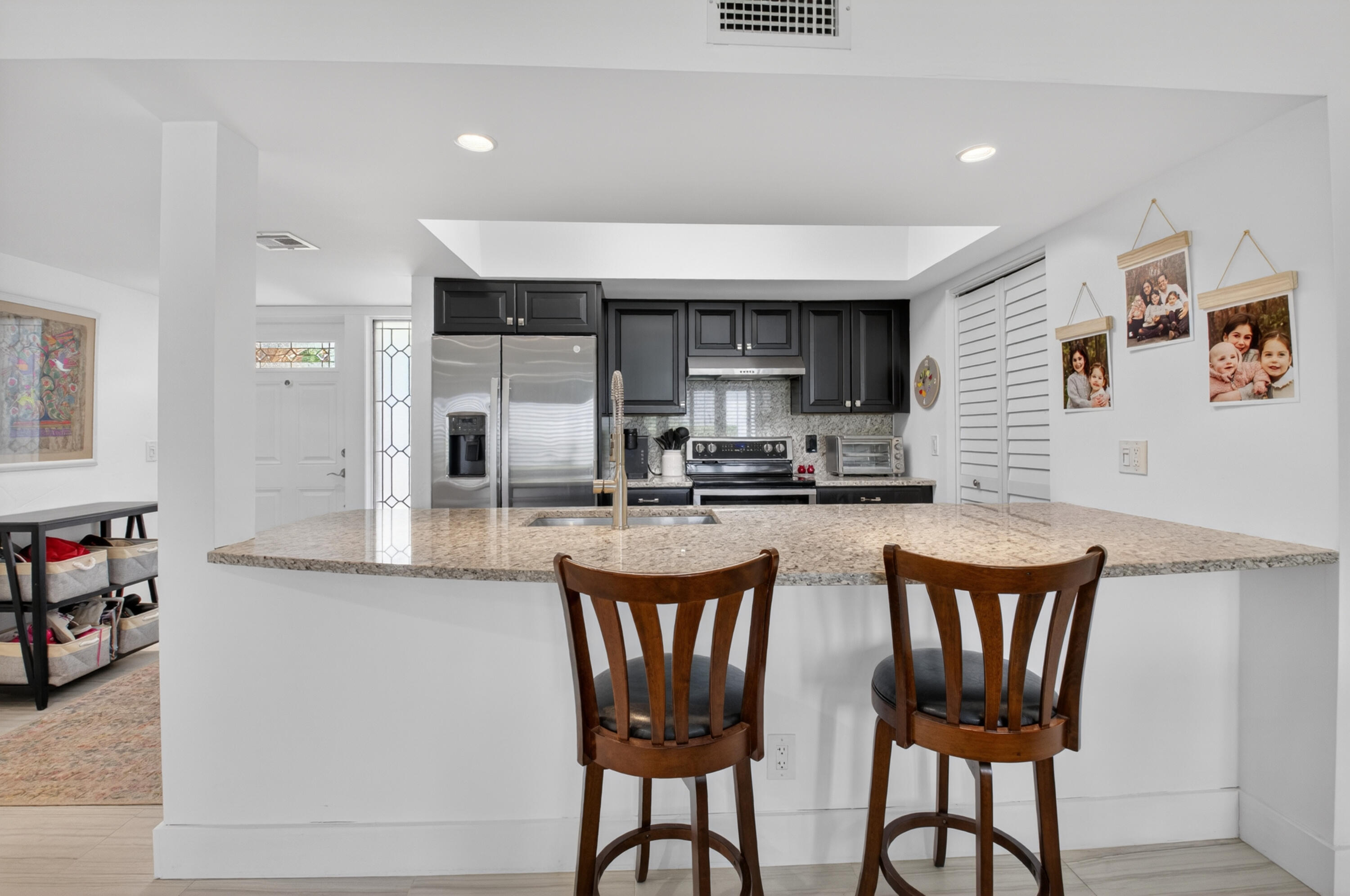 19981 Boca W Drive, Unit 3123 Boca Raton, FL 33434 - Photo 13 of 57 a kitchen with stainless steel appliances granite countertop a dining table chairs and a refrigerator