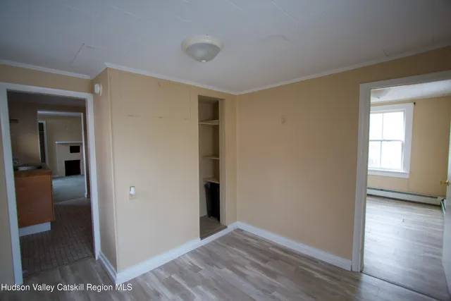 a view of hallway with a room and wooden floor