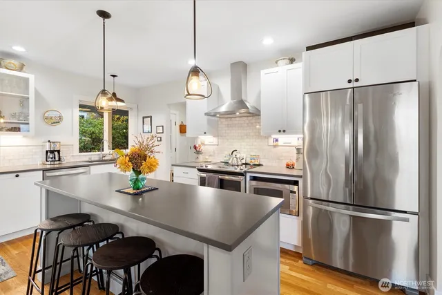 a kitchen with kitchen island a counter appliances a sink and a center island