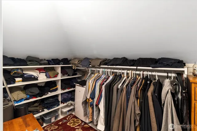 a view of walk in closet with clothes and shoes