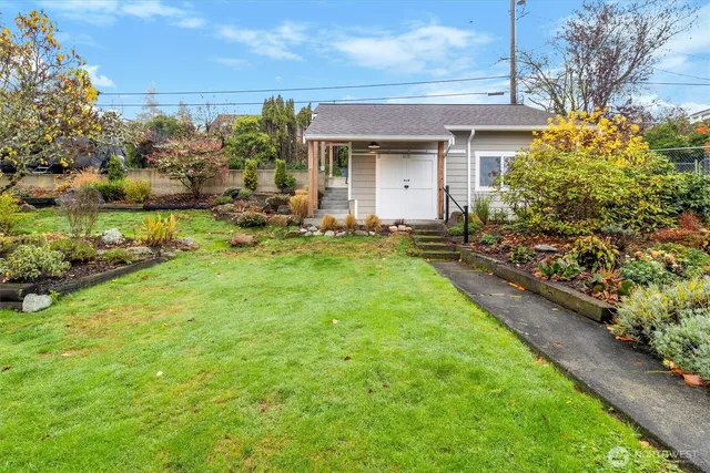 a front view of house with yard and trees in the background