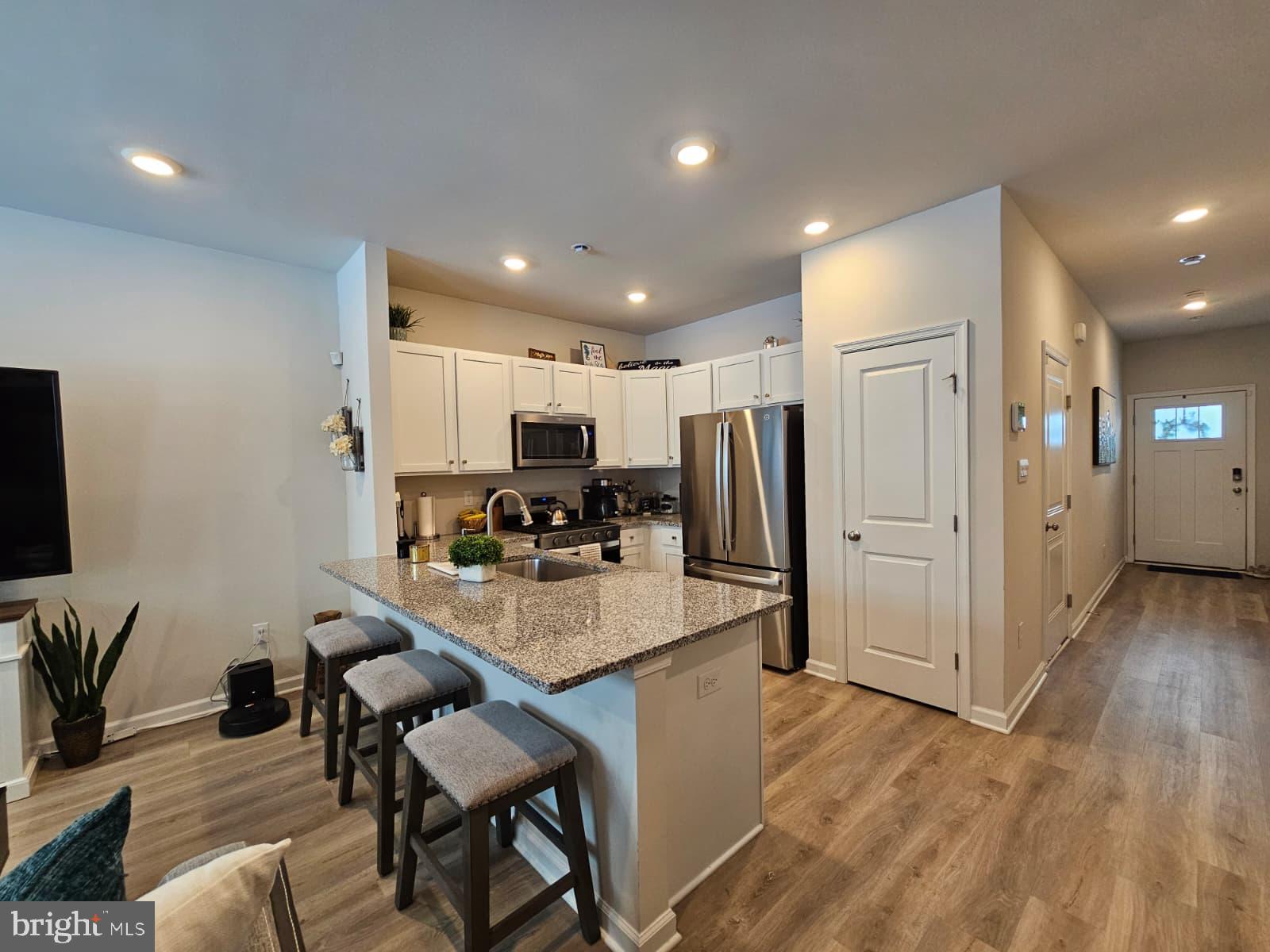 a kitchen with stainless steel appliances kitchen island granite countertop a refrigerator and a stove top oven