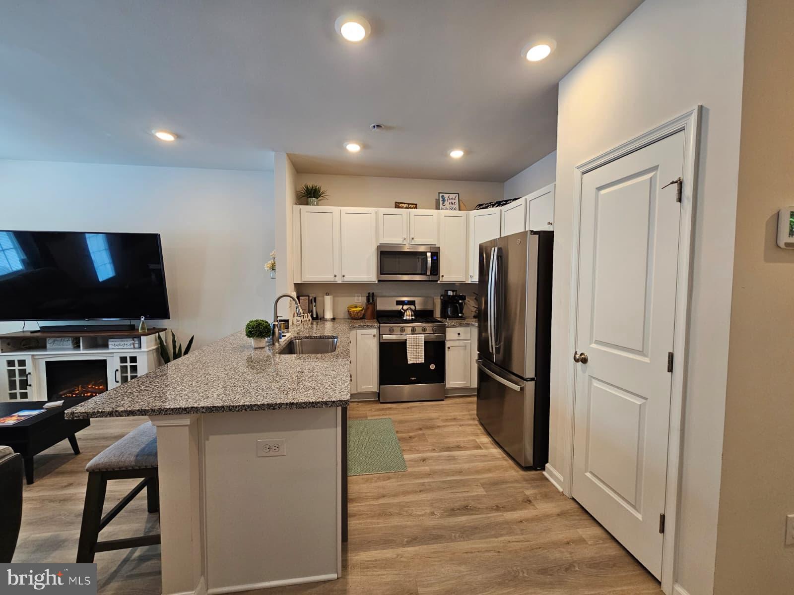 33 Alexander Way Westampton, NJ 08060 - Photo 4 of 18 a kitchen with stainless steel appliances granite countertop a refrigerator oven a sink dishwasher and white cabinets with wooden floor
