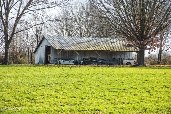 a front view of house with a yard and large trees