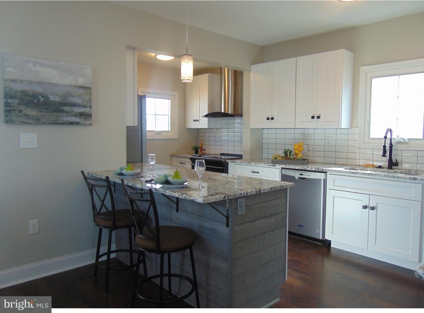 124 Ronald Road Aston, PA 19014 - Photo 4 of 25 a kitchen with a dining table chairs and cabinets