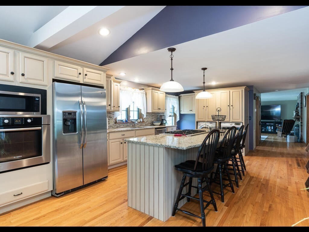 151 Ames Road Hampden, MA 01036 - Photo 11 of 41 a kitchen with stainless steel appliances a dining table chairs stove and refrigerator