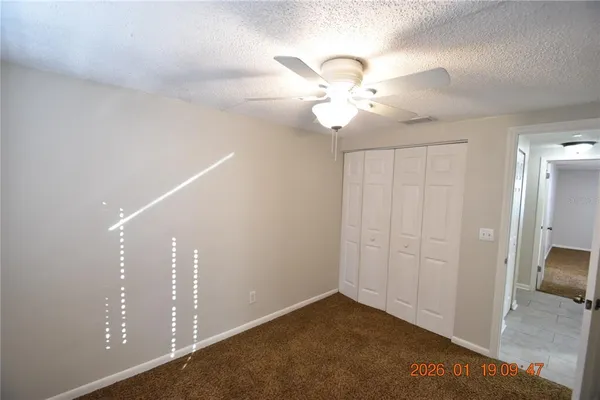 an empty room with fan and entrance