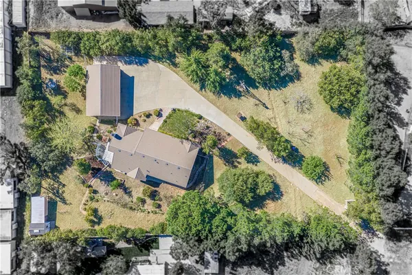 an aerial view of a house with a yard and trees