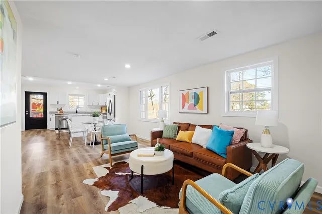 a living room with furniture and a wooden floor
