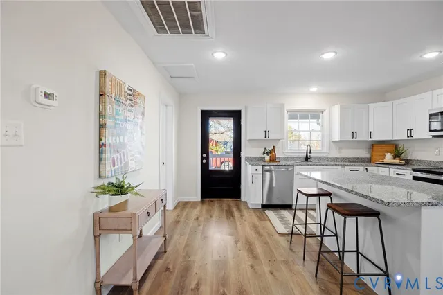 a kitchen with granite countertop white cabinets and refrigerator