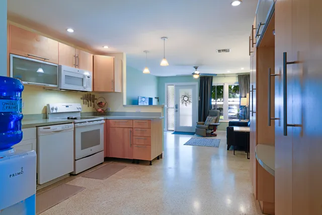 a kitchen that has a lot of cabinets a sink and appliances in it