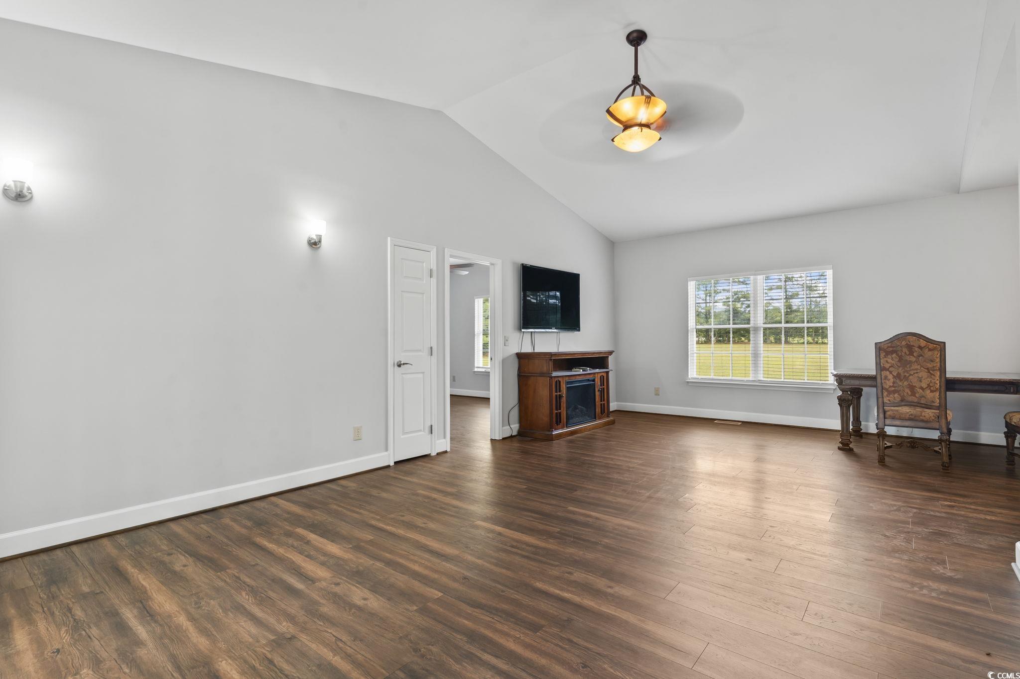 1585 Daisy Road Loris, SC 29569 - Photo 11 of 39 Unfurnished living room with lofted ceiling, healthy amount of natural light, and dark wood-style flooring