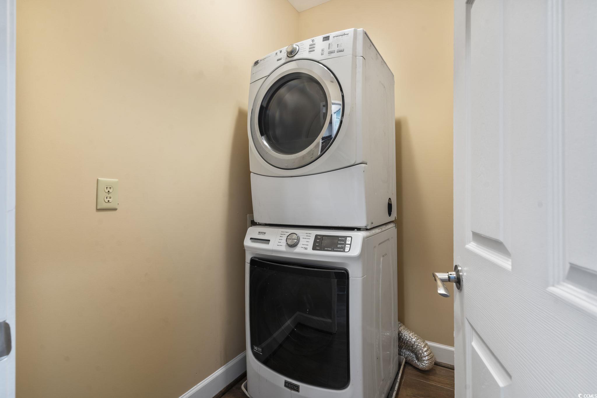 1585 Daisy Road Loris, SC 29569 - Photo 23 of 39 Laundry room with estacked washer and dryer and dark wood-style flooring