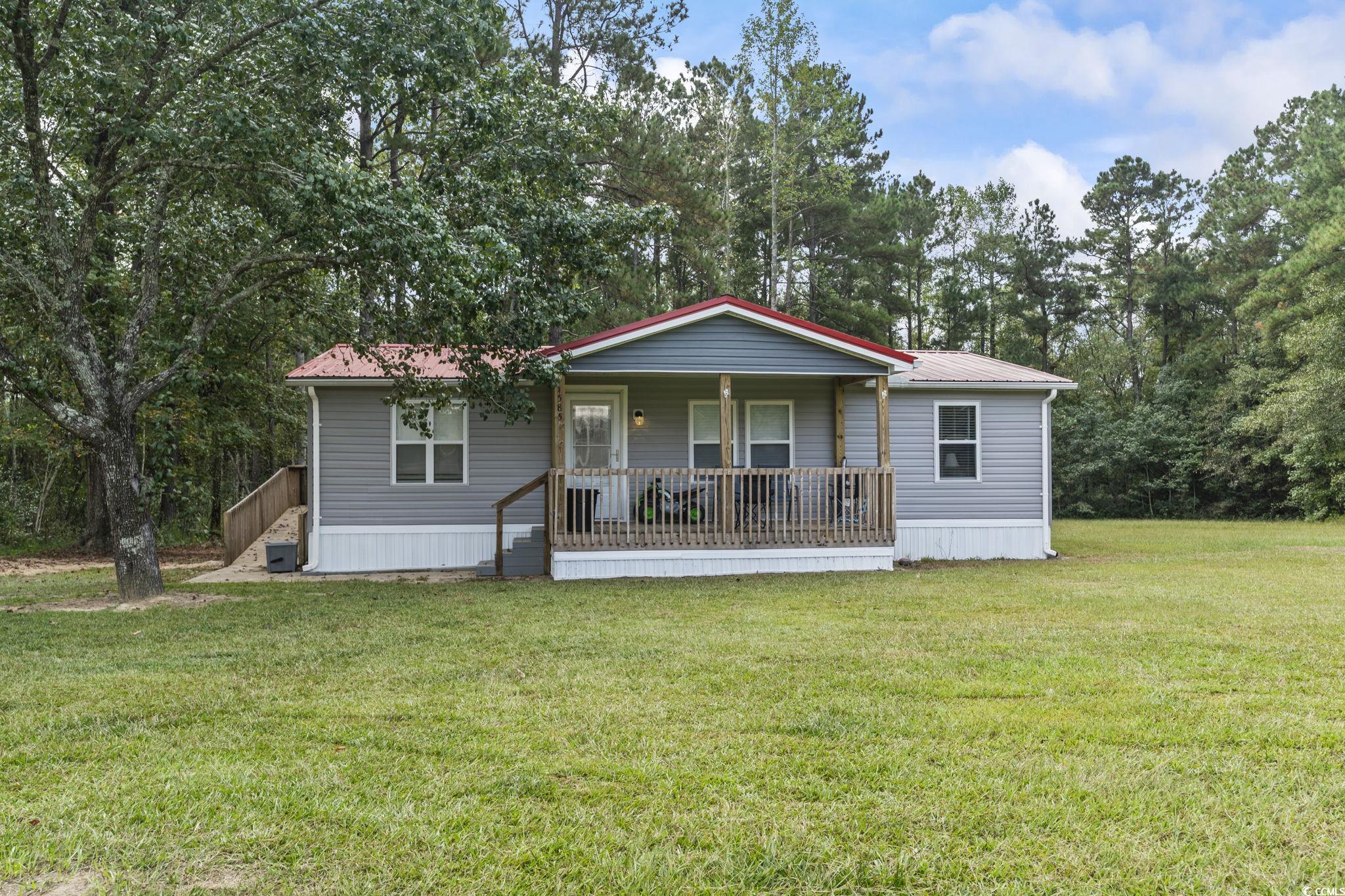 1585 Daisy Road Loris, SC 29569 - Photo 27 of 39 Manufactured / mobile home with a front lawn, a porch, a metal roof, and view of wooded area