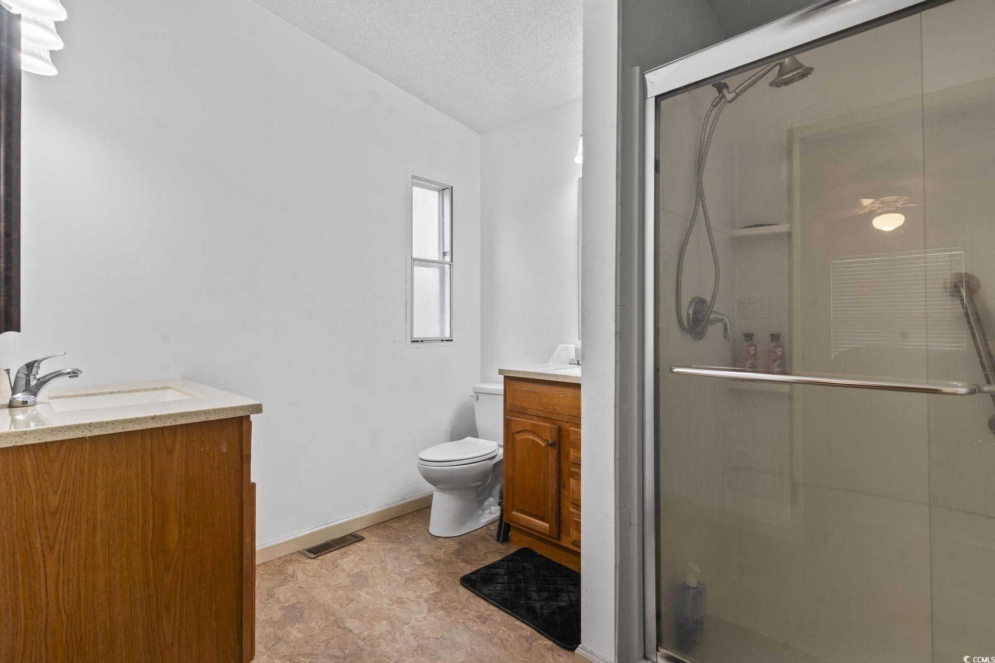 1585 Daisy Road Loris, SC 29569 - Photo 32 of 39 Bathroom with vanity, a stall shower, and a textured ceiling