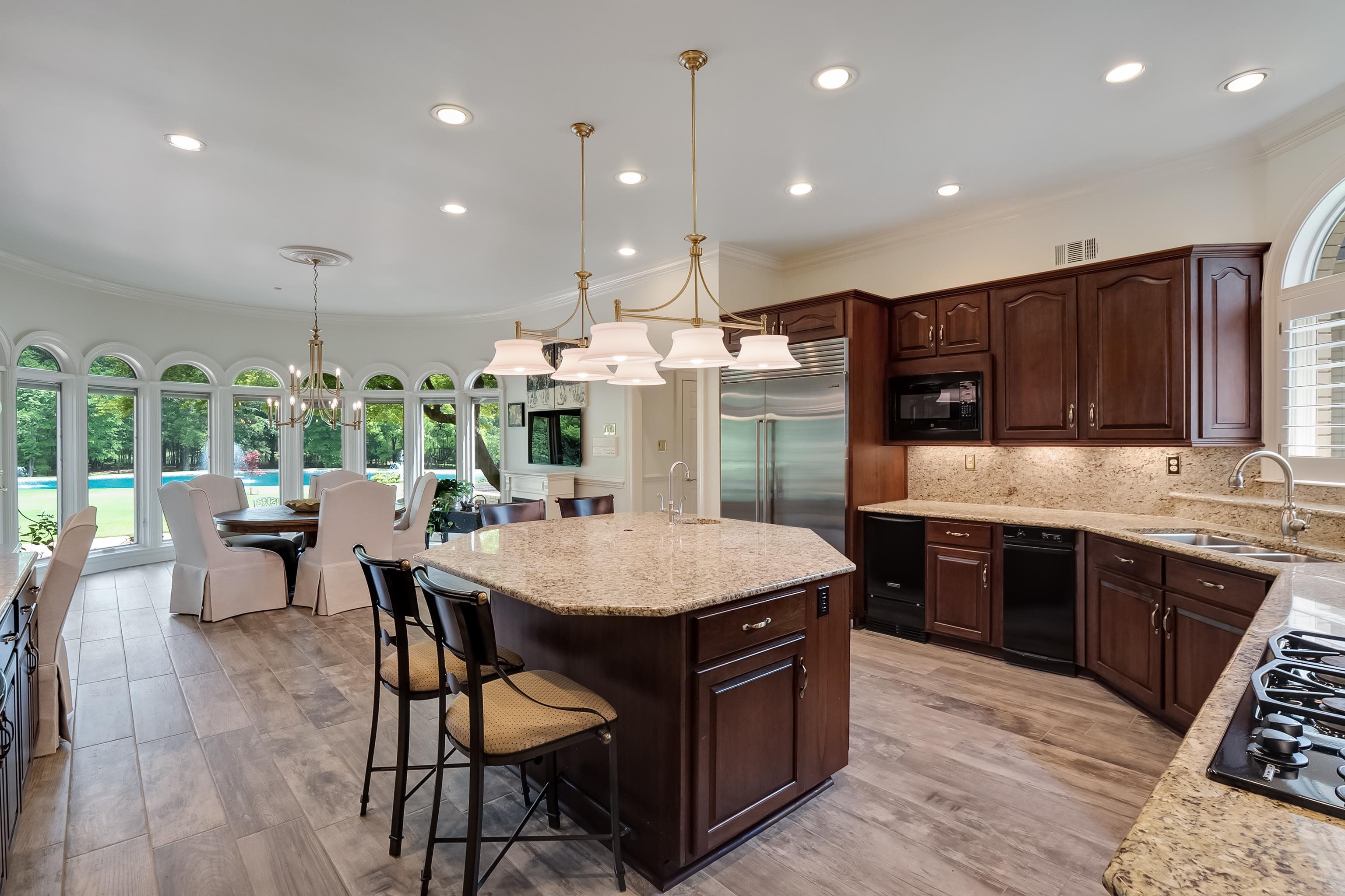 3044 Shea Road Collierville, TN 38017 - Photo 12 of 40 a kitchen with stainless steel appliances kitchen island granite countertop a table chairs sink and cabinets