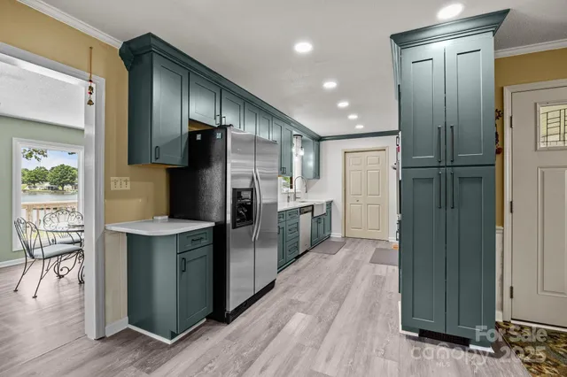 a kitchen with stainless steel appliances a refrigerator and a wooden floor
