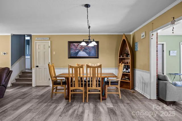 a dining room with furniture entryway and wooden floor
