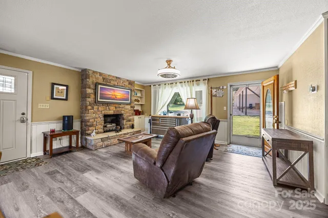 a living room with furniture a large window and wooden floor