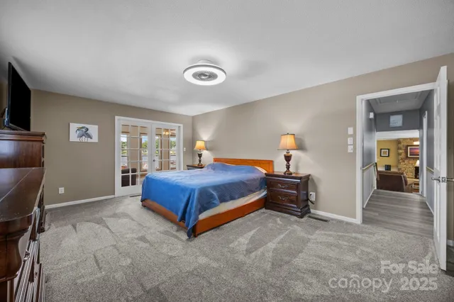 a bedroom with a bed and a flat tv screen on dresser