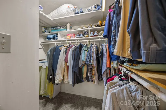 a view of walk in closet with clothes