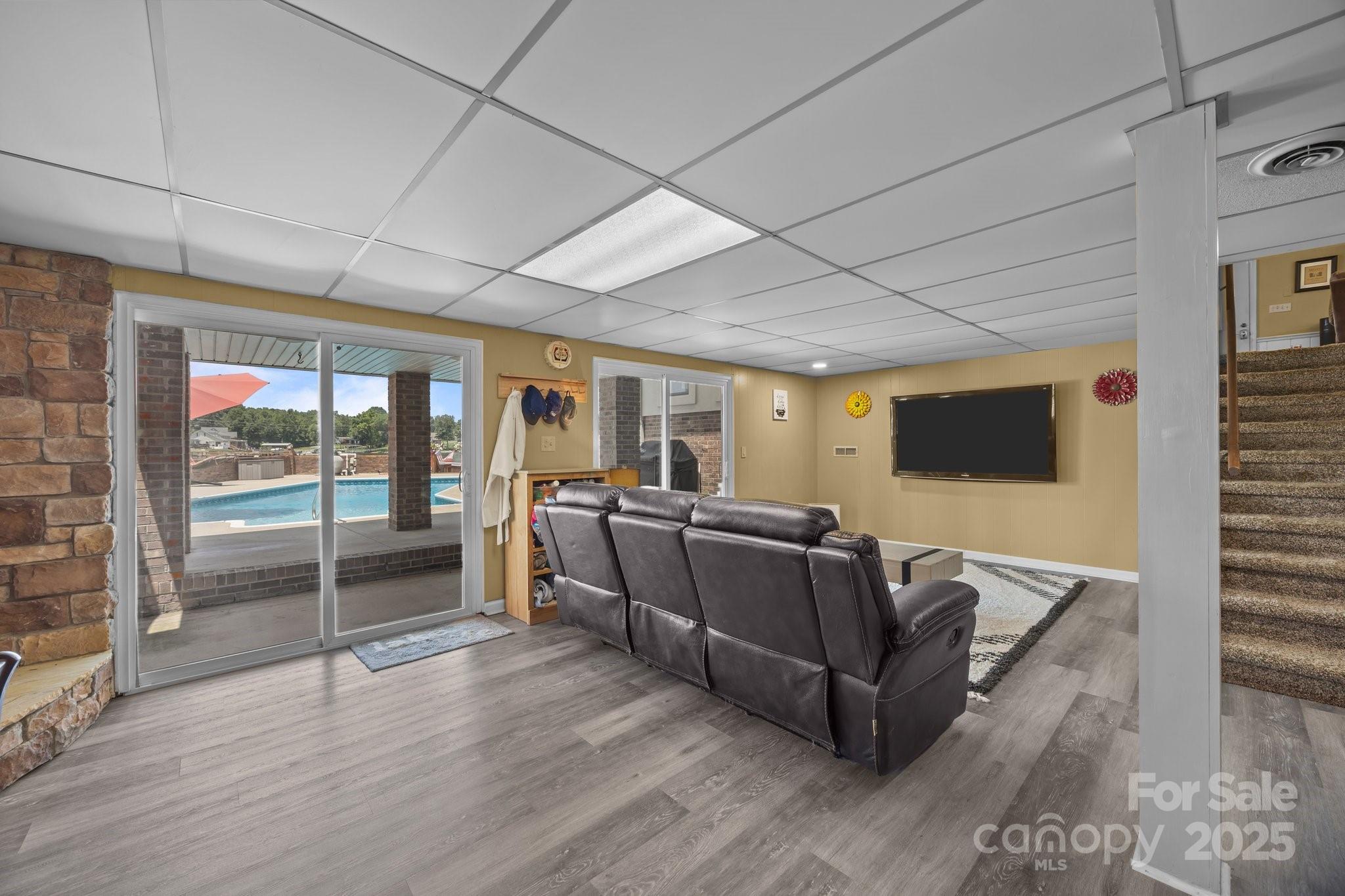 1017 Holloway Church Road Lexington, NC 27292 - Photo 29 of 48 a living room with furniture a flat screen tv and a floor to ceiling window