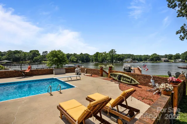 a view of swimming pool with outdoor seating and lake view