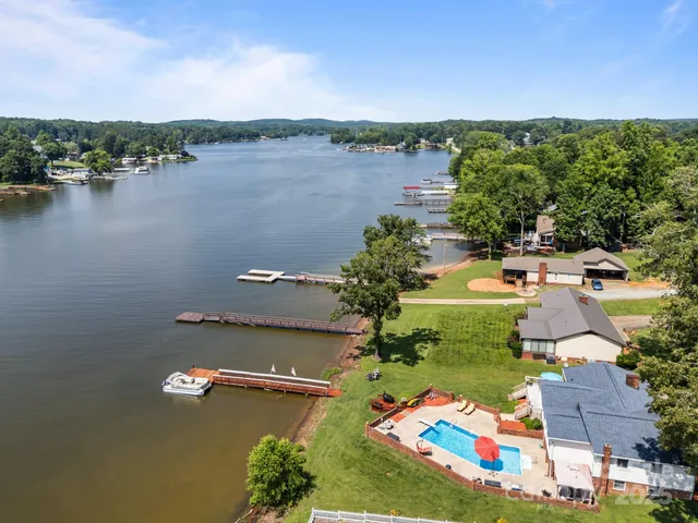 an aerial view of residential houses with outdoor space and lake view
