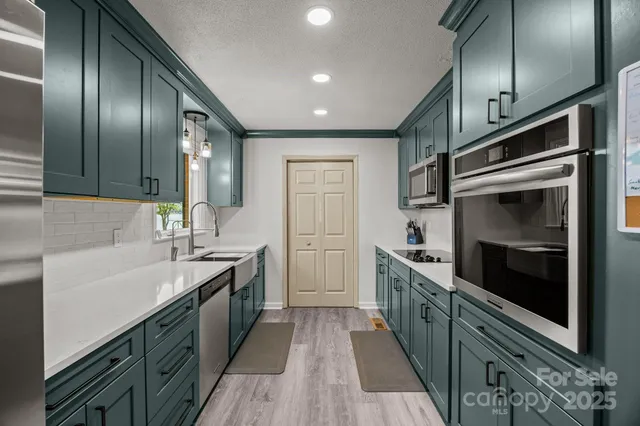 a kitchen with stainless steel appliances a sink stove and cabinets
