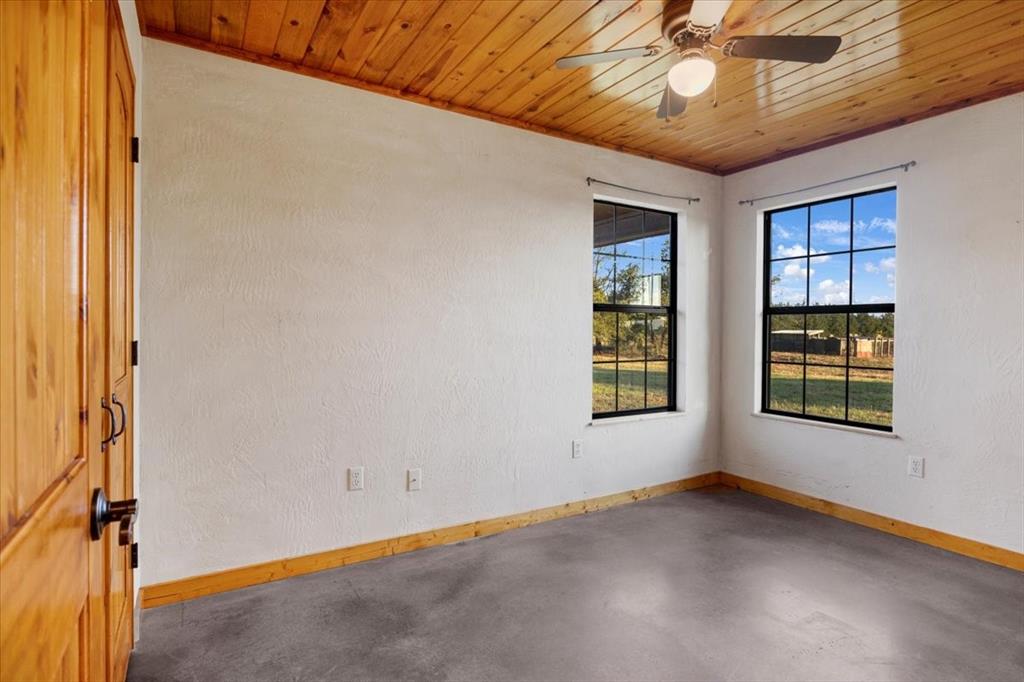 1809 County Road Winnsboro, TX 75494 - Photo 11 of 39 an empty room with windows and chandelier fan