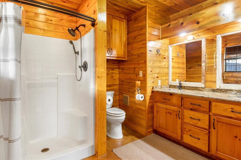 1809 County Road Winnsboro, TX 75494 - Photo 19 of 39 a bathroom with a granite countertop sink a toilet and shower