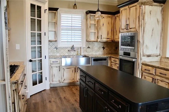 a kitchen with kitchen island wooden floor center island and stainless steel appliances