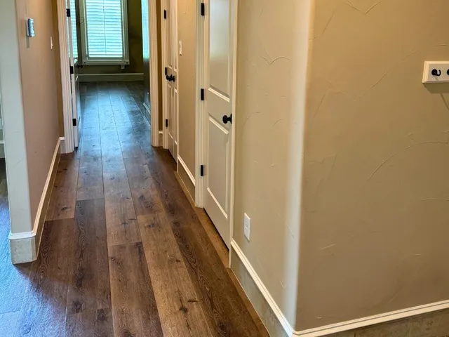 a view of a hallway with wooden floor
