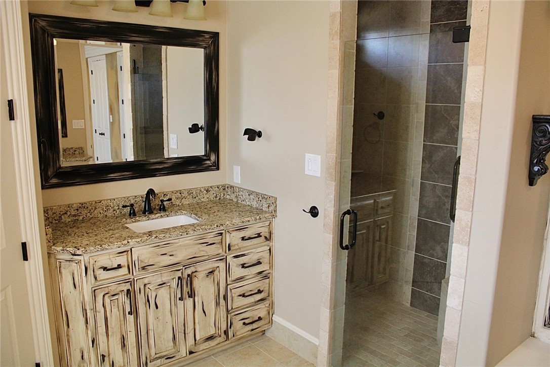 100 Deer Creek Drive Waco, TX 76708 - Photo 18 of 26 a bathroom with a sink vanity and a mirror
