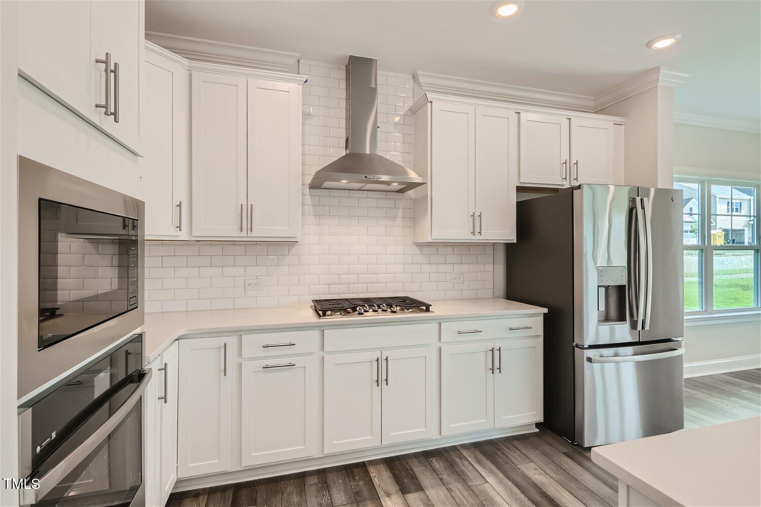 128 Eden View Bend, Unit 672 Raleigh, NC 27610 - Photo 2 of 16 a kitchen with stainless steel appliances white cabinets and a refrigerator