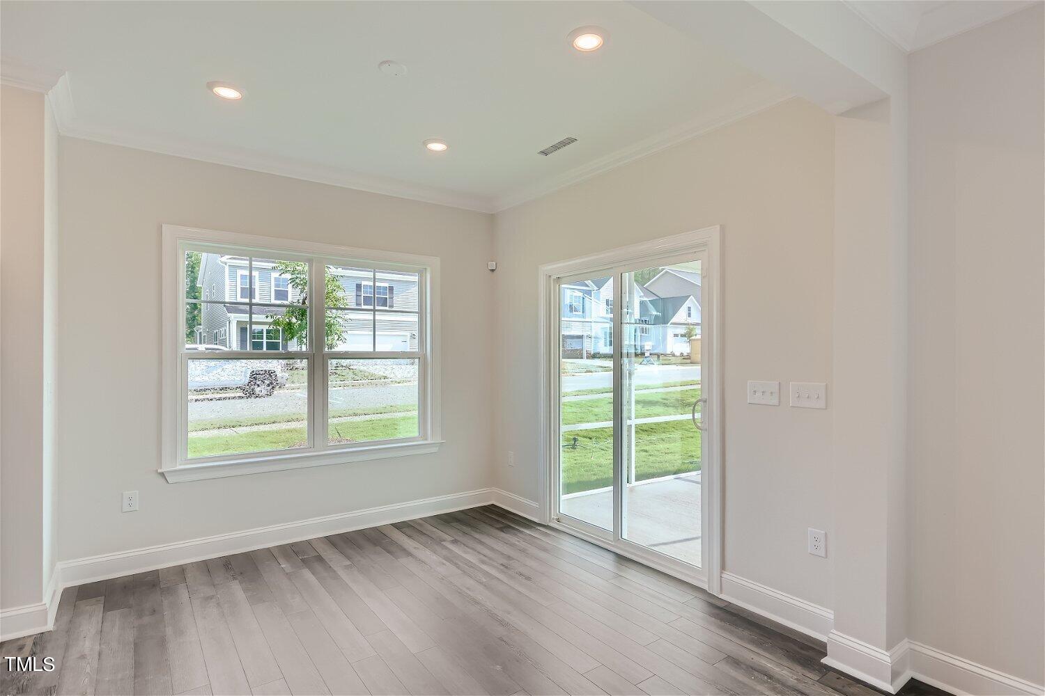 128 Eden View Bend, Unit 672 Raleigh, NC 27610 - Photo 6 of 16 an empty room with wooden floor and windows
