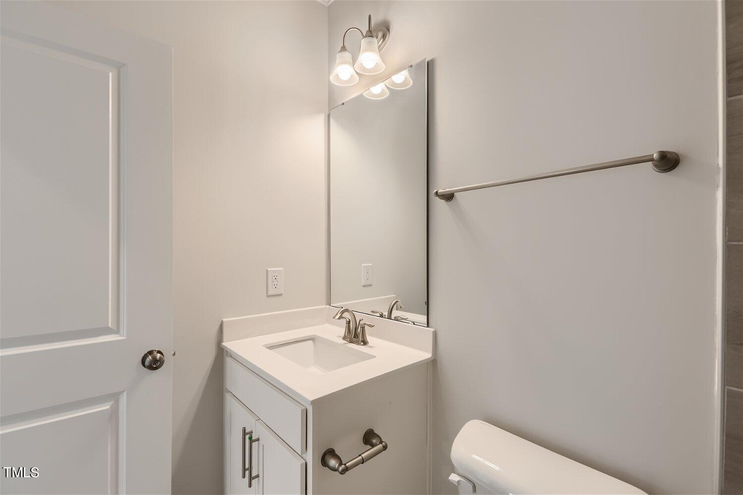 128 Eden View Bend, Unit 672 Raleigh, NC 27610 - Photo 7 of 16 a bathroom with a sink a toilet and a mirror