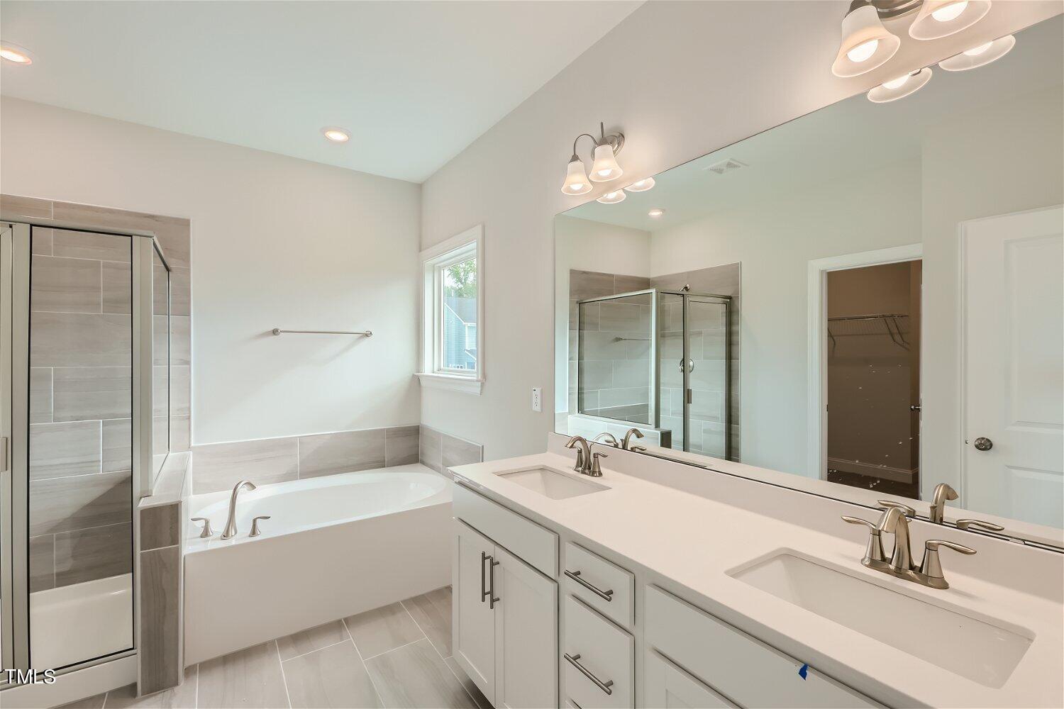 128 Eden View Bend, Unit 672 Raleigh, NC 27610 - Photo 9 of 16 a bathroom with a bathtub a sink and mirror