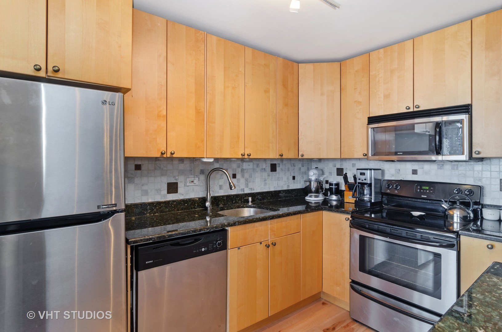 655 Irving Park Road, Unit 4606 Chicago, IL 60613 - Photo 7 of 15 a kitchen with granite countertop a refrigerator stove and microwave