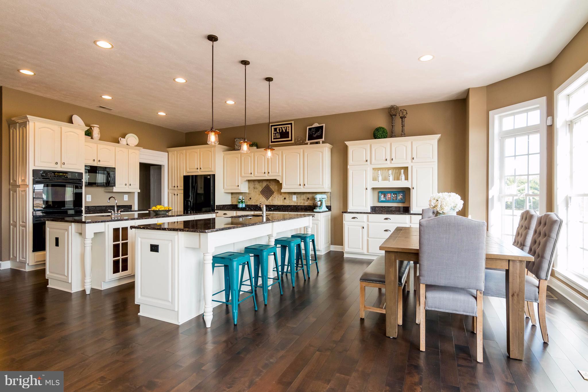 2404 Long Ridge Road Reisterstown, MD 21136 - Photo 11 of 30 a kitchen with stainless steel appliances kitchen island granite countertop a table chairs and a refrigerator