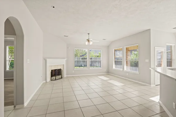 a view of an empty room with a fireplace and a window