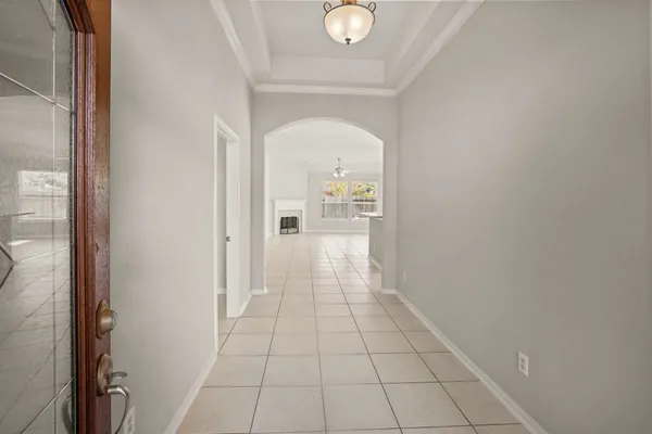 a view of a hallway with wooden floor and a bathroom
