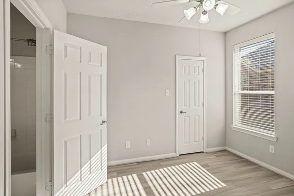 a view of a bedroom with a bed and wooden floor