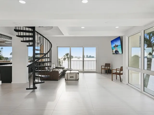a living room with furniture floor to ceiling window and a flat screen tv