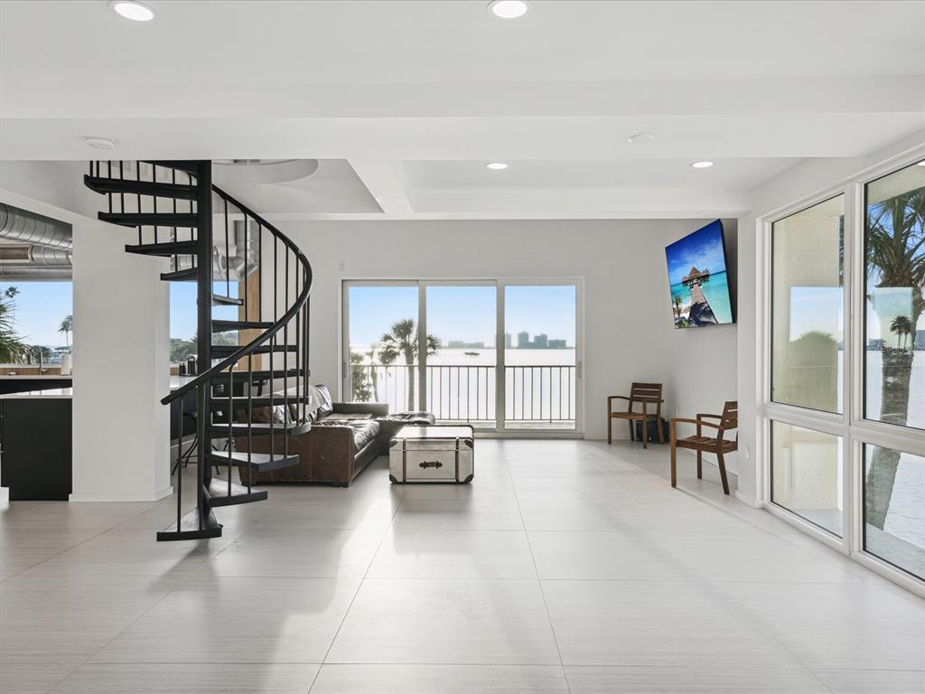 50 Coe Road, Unit 126 Belleair, FL 33756 - Photo 9 of 39 a living room with furniture floor to ceiling window and a flat screen tv