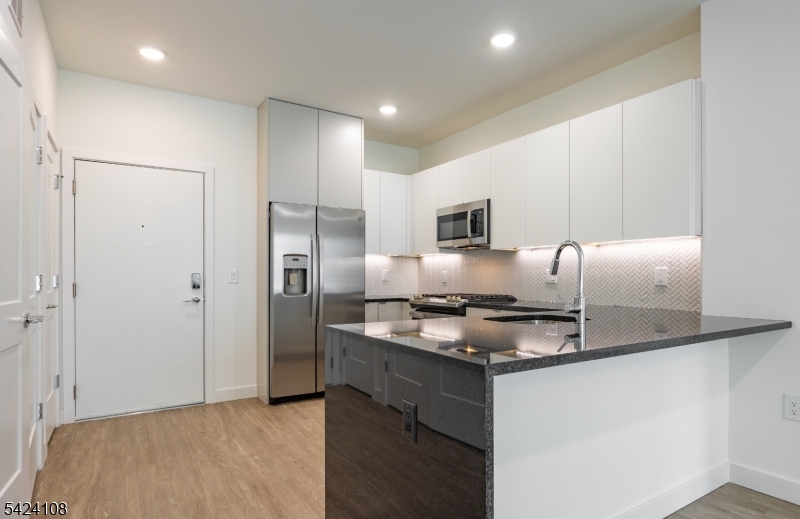 558 Market Street Newark, NJ 07105 - Photo 4 of 17 a kitchen with kitchen island a counter top space cabinets and stainless steel appliances