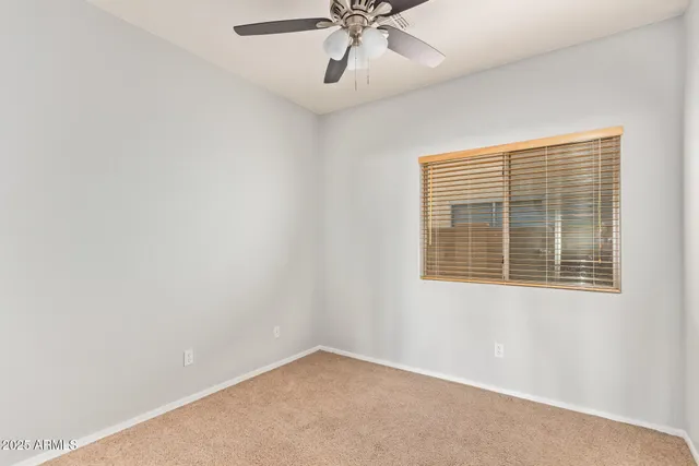 an empty room with a window and a fan