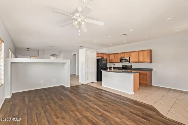 a kitchen with stainless steel appliances kitchen island sink refrigerator and cabinets