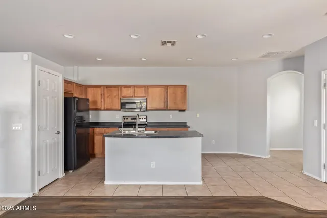 a kitchen with stainless steel appliances granite countertop a refrigerator a stove and a sink